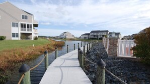Un paseo marítimo que conduce a una urbanización cerrada con casas modernas.