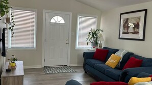 A living room with a blue sofa, a wooden coffee table, and a door with a glass window.