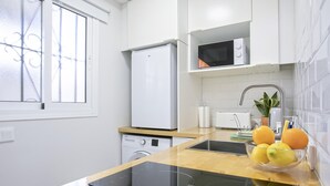 Een moderne keuken met een inbouwoven, magnetron en spoelbak.