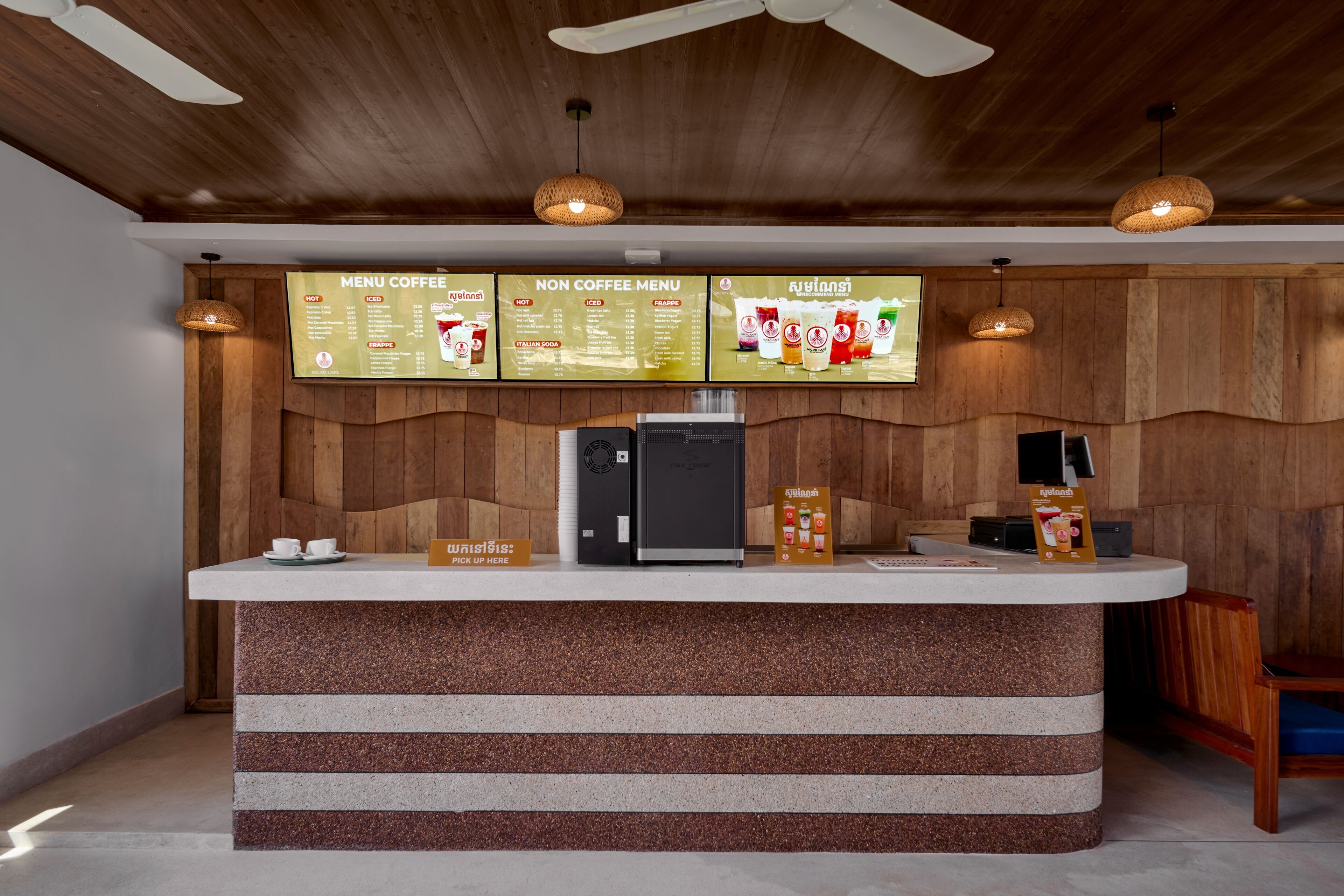 A coffee station with a menu board, a coffee machine, and a counter.
