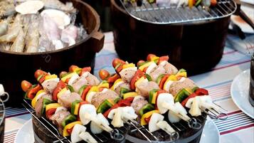 Skewers of meat and vegetables on a grill.