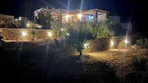 A well-lit building with stone walls and a garden area.