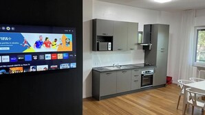 A modern kitchen with grey cabinets, a microwave, and a sink. - Villa Riviera 287 - Appartamento Mare (Pescara)