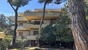 A multi-story building with a flat roof, balconies, and a paved courtyard. - Villa Riviera 287 - Appartamento Mare (Pescara)