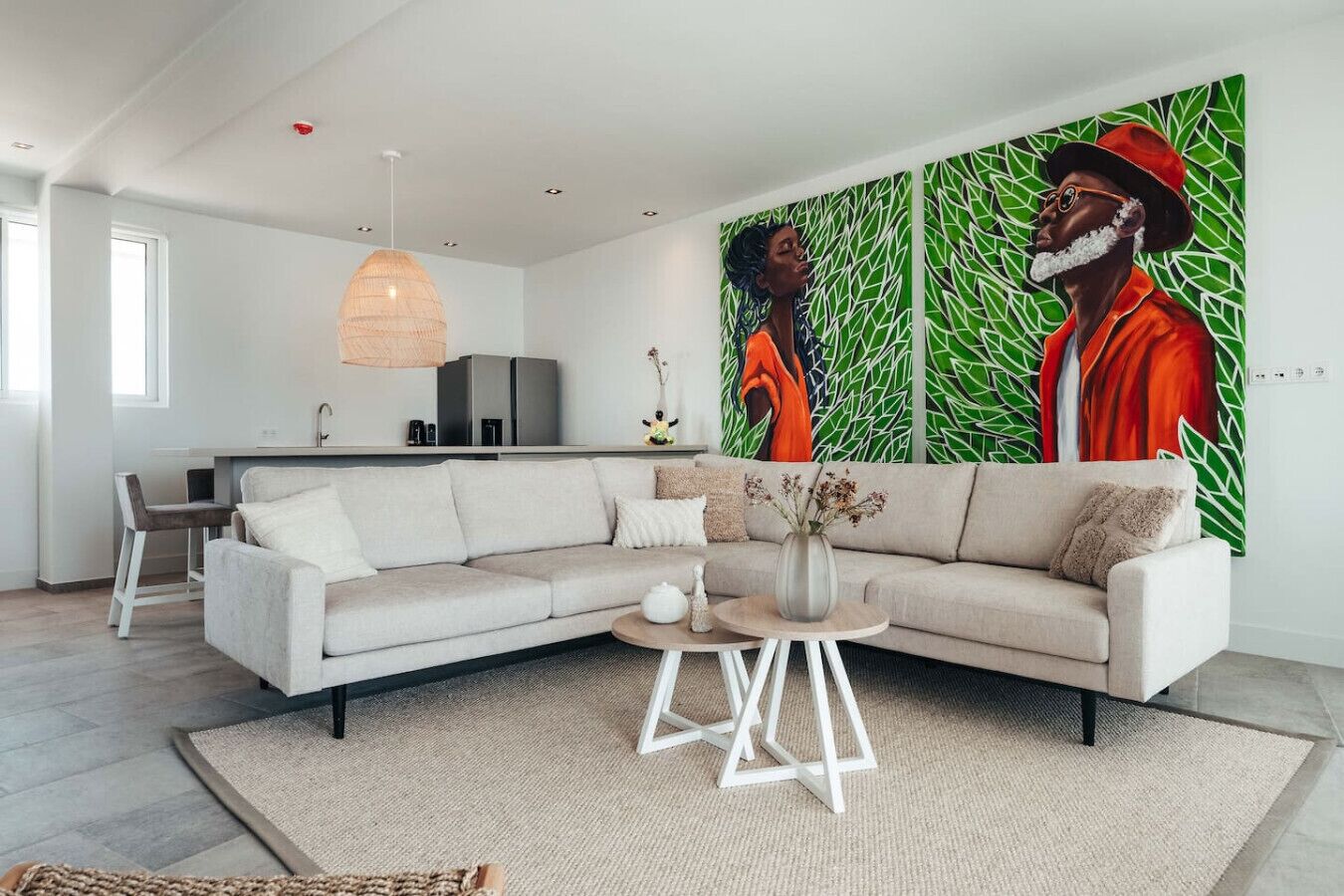 A modern living room with a sectional sofa, a round coffee table, and a large abstract painting on the wall.
