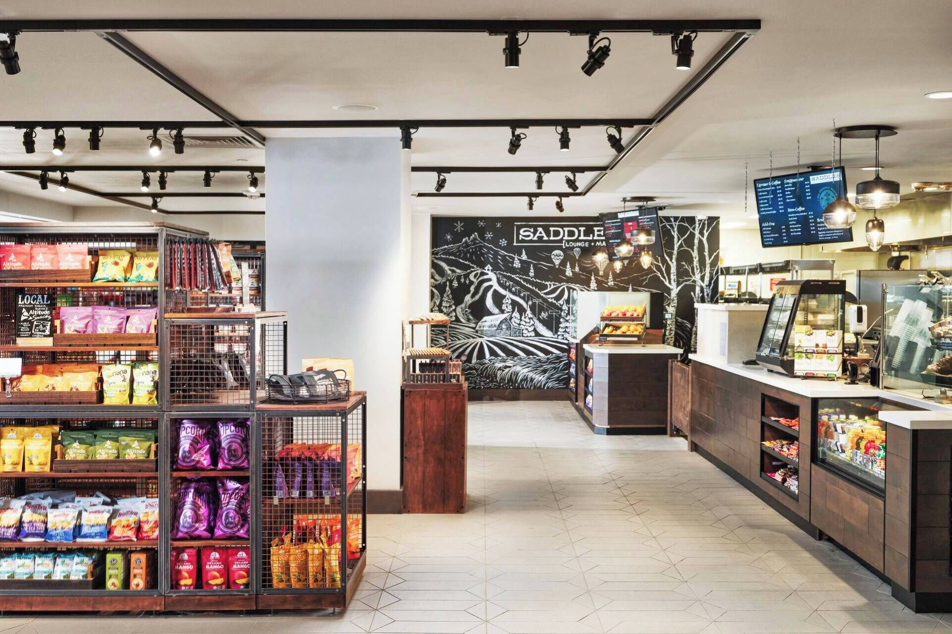 En modern butik med avdelningar för snacks, en kaffebar och en väggmålning.