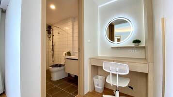 Ein modernes Badezimmer mit Dusche, Toilette und Waschtisch inklusive Spiegel und Waschbecken.