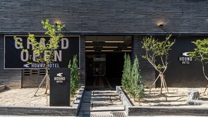 Das Grand Open Hound Hotel mit moderner Architektur, mit einer Holzfassade und einem Schild.