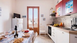 A compact kitchen with a dining area, a refrigerator, a sink, and a stove. - Rifugio Al Mare, Ac, Wifi, San Foca (San Foca)