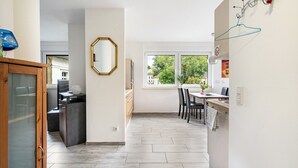 Una cocina moderna con comedor, un ventanal grande y un pasillo que lleva a otra habitación.