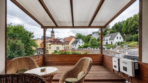 Un espacio al aire libre cubierto con mobiliario de mimbre y vistas a edificios.