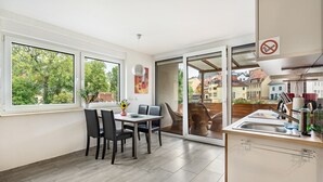 Una cocina moderna con comedor, ventanas amplias y vistas a la ciudad.
