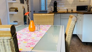 Une cuisine moderne avec des meubles blancs, un four à micro-ondes et une machine à café.