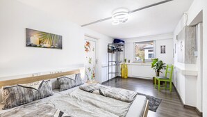Une chambre à coucher avec un lit, une chaise, un tableau et une fenêtre.