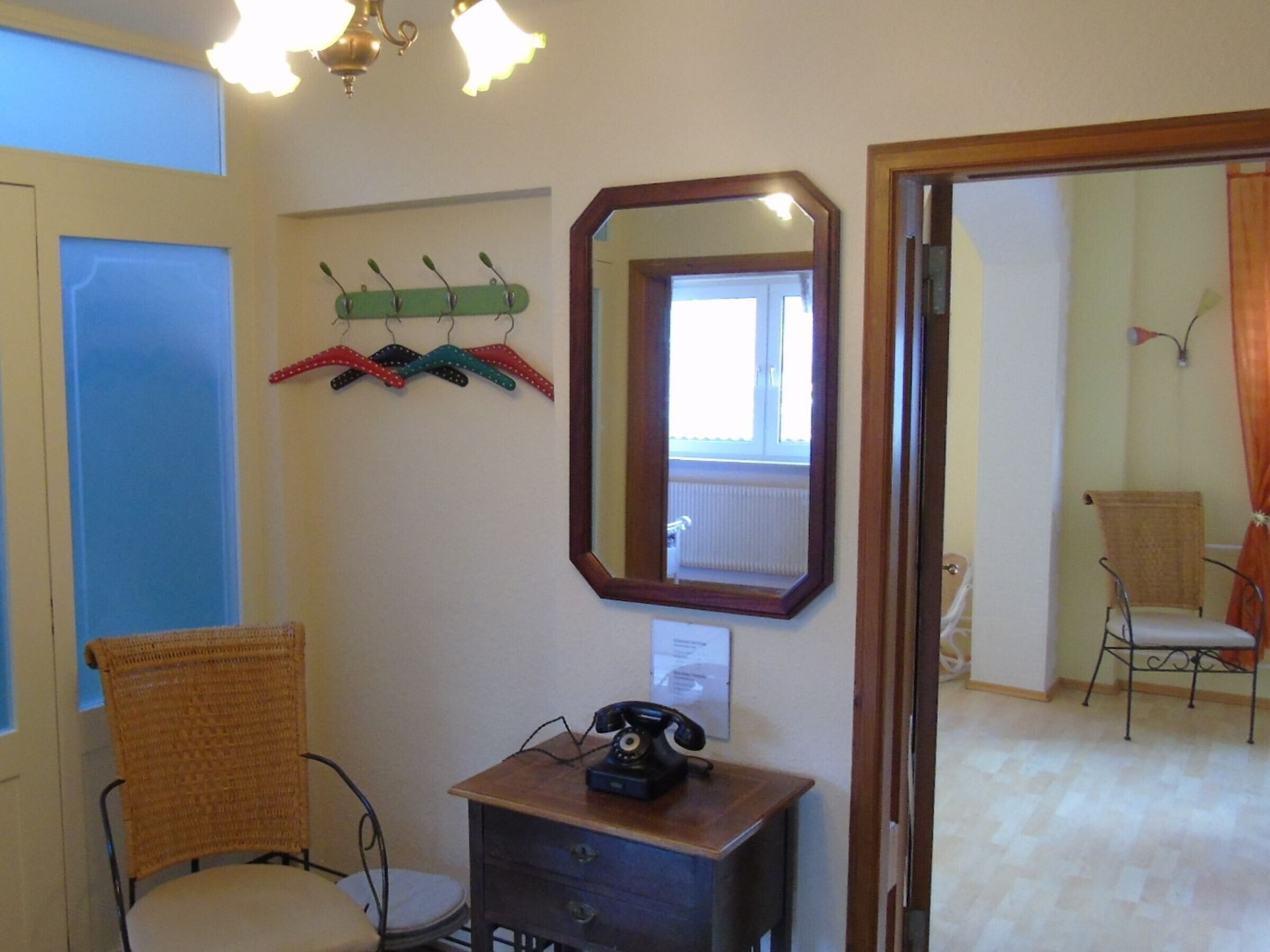 Une pièce comprenant un bureau en bois, un téléphone, un miroir et une chaise.