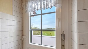 Een deur met een raam, een slot en uitzicht op een groen veld.