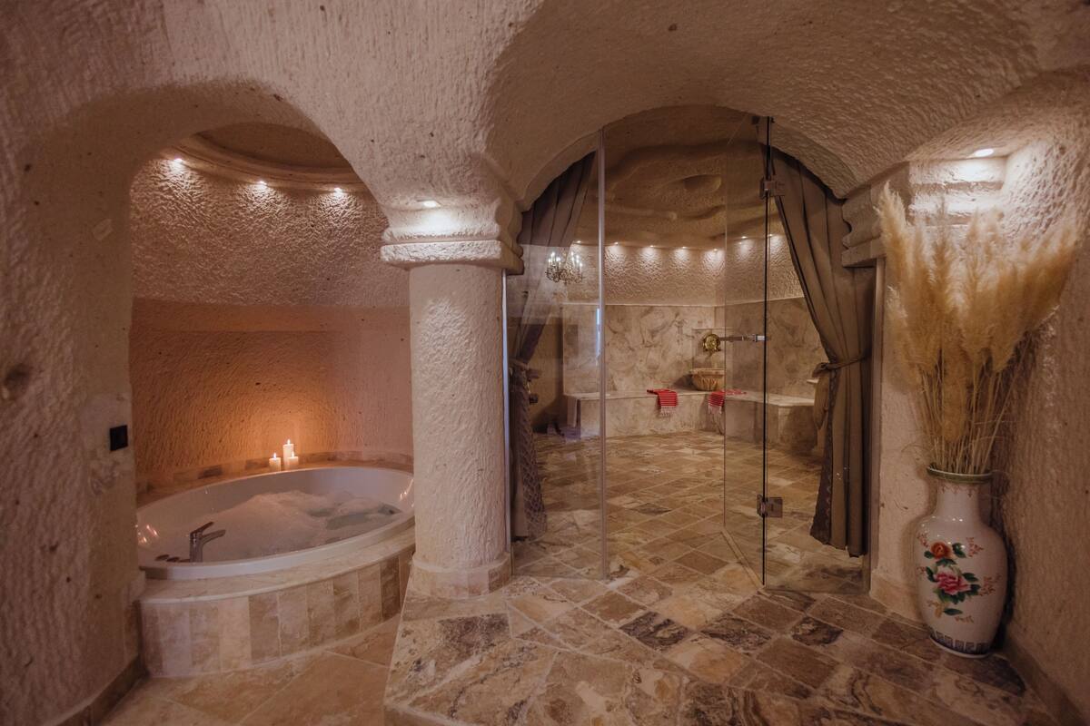 Senior suite (Caves) | Badkamer | Een aparte badkuip en douche, een haardroger, pantoffels, handdoeken