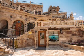 Un edificio histórico con una zona de recepción, paredes de piedra y un cartel que dice 'The Kingdom of Cappadocia'.
