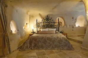 Une chambre à coucher avec un lit, une table de chevet, une lampe et un rideau.