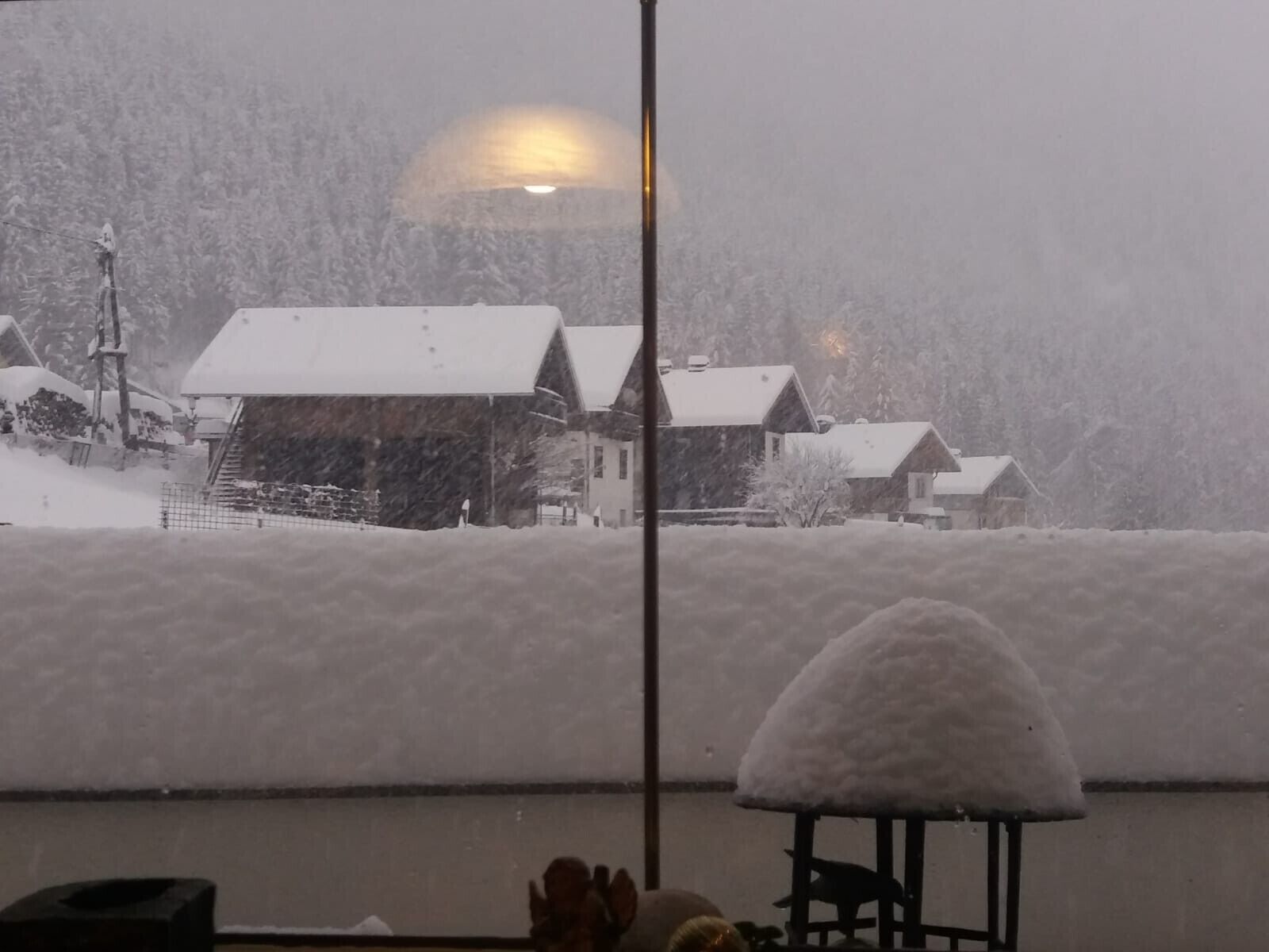 Un paysage enneigé avec des maisons et une grande structure recouverte de neige au premier plan.