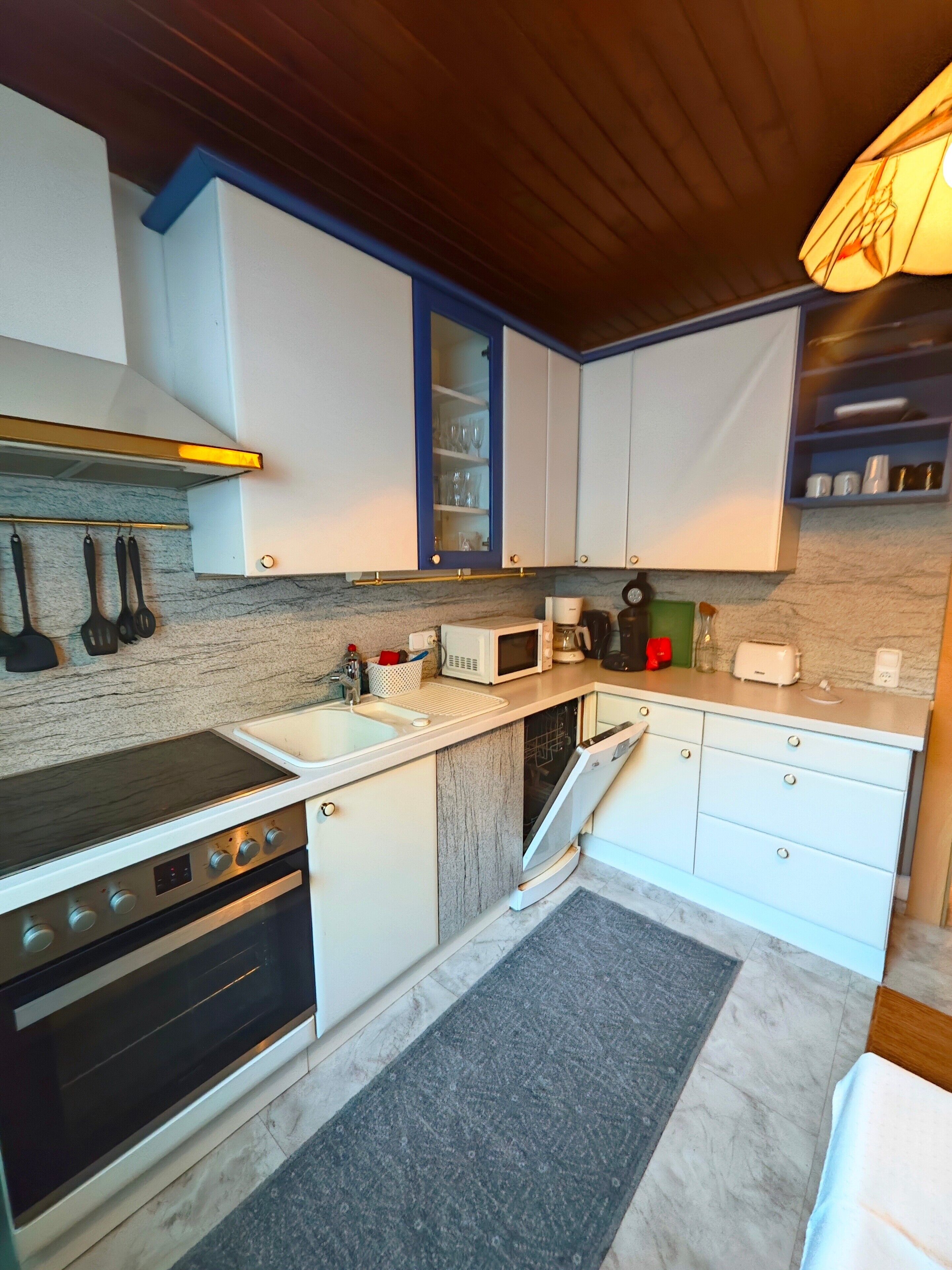 A modern kitchen with white cabinets, a built-in microwave, a stove, and a dishwasher.