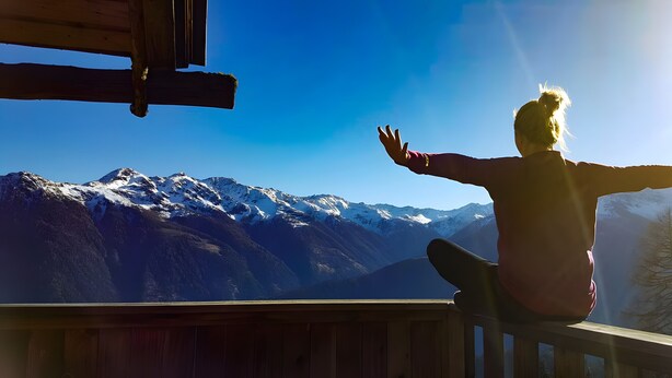 A person sitting on a wooden deck with a mountain view. - Apartment 'Gina' with Mountain Views, Private Garden and Wi-Fi (Stall)