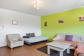 Una sala de estar moderna con un sofá, un sillón y una mesita.