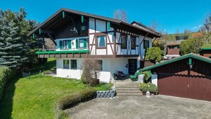 Een herenhuis met een balkon, een voordeur en een oprit naar een garage.