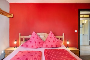 A bed with a wooden headboard, two bedside lamps, and star-patterned bedding.