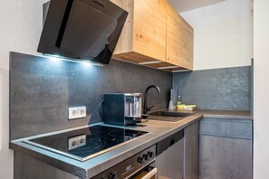 Une cuisine moderne équipée d’une cuisinière, d’un four et d’une machine à café intégrés.