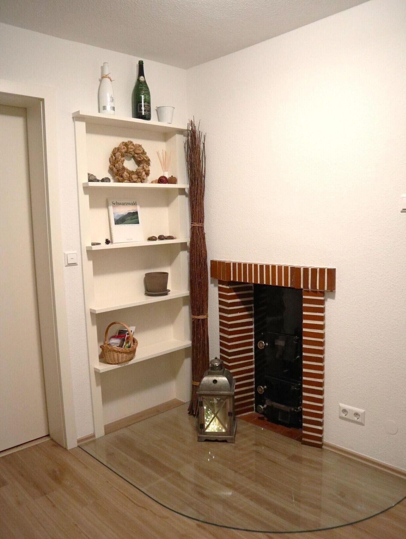 Ein Zimmer mit Kamin, Regalen mit diversen Gegenständen, einer Laterne und einer Tür.