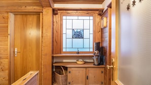 A wooden cabin interior with a window, a sink, a basket, and a cabinet. - Apartment 'Museumsblick' with Mountain View and Wi-Fi (Mittenwald)