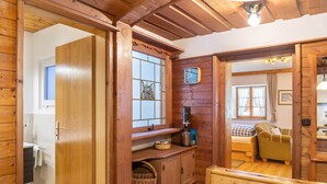 A wooden interior with a bed, a chair, a window, and a wooden cabinet. - Apartment 'Museumsblick' with Mountain View and Wi-Fi (Mittenwald)