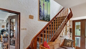 A wooden staircase with a bench at the bottom, a door with a glass panel, and a painting on the wall. - Room 'Panorama' with Shared Terrace, Shared Garden and Wi-Fi (Dornstetten)