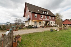A two-story building with a sign reading 'Cafe Waldiesel Pension.'