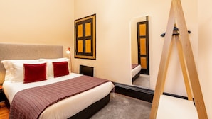 A hotel room with a bed, a wooden ladder, a mirror, and a door with a window. - Cosy apartment in heart of Porto (Oporto)