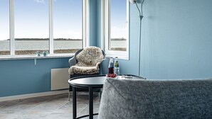 A room with a view of the sea, a chair, a table, and a lamp. - "Nyalle" - 50m to the fjord by Interhome (Struer)