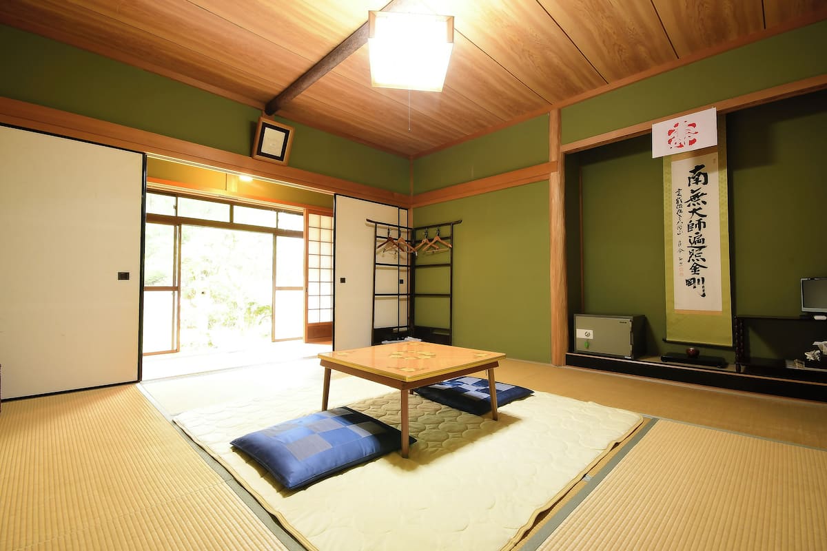Ein traditioneller japanischer Raum mit Tatami-Bodenbelag, einem niedrigen Holztisch und einer Shoji-Schiebetür.