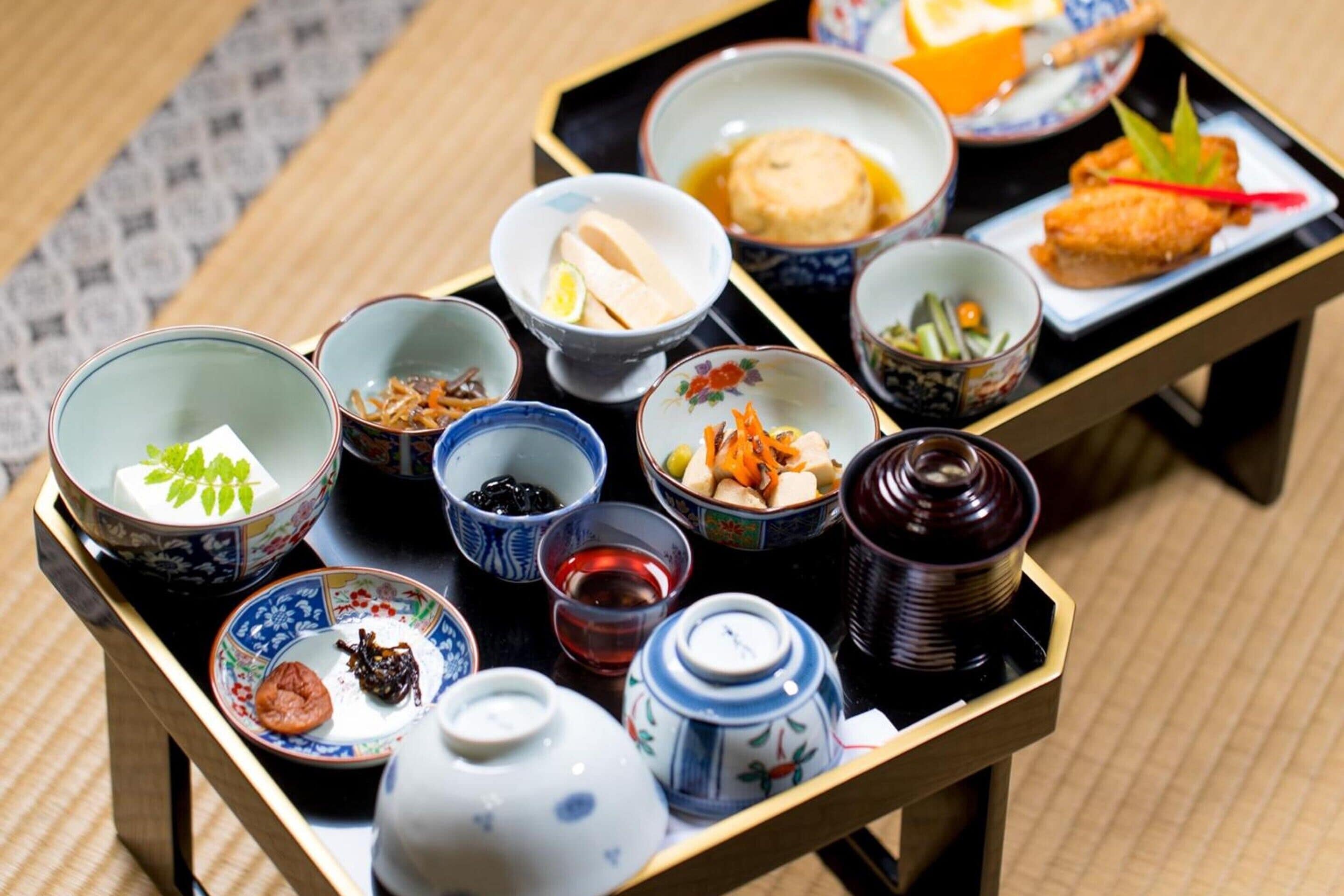 Un service à thé japonais traditionnel, comprenant divers plats et ustensiles, disposés sur un plateau.