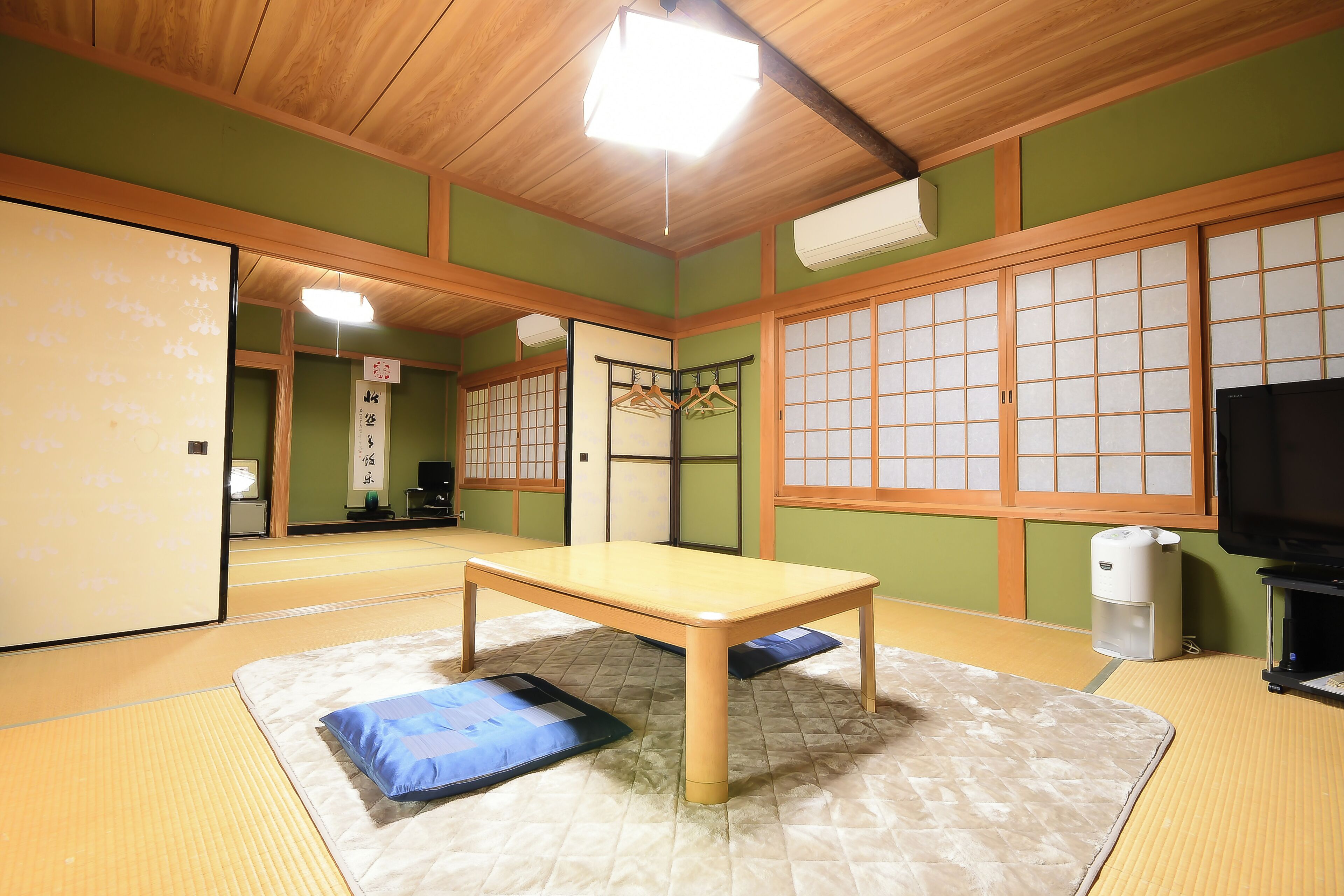 A traditional Japanese room with tatami flooring, a low wooden table, and shoji screens.