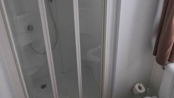 Ein Badezimmer mit einer Duschkabine, Toilette und einem Handtuchhalter.