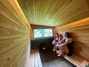 A wooden sauna with benches and a window.