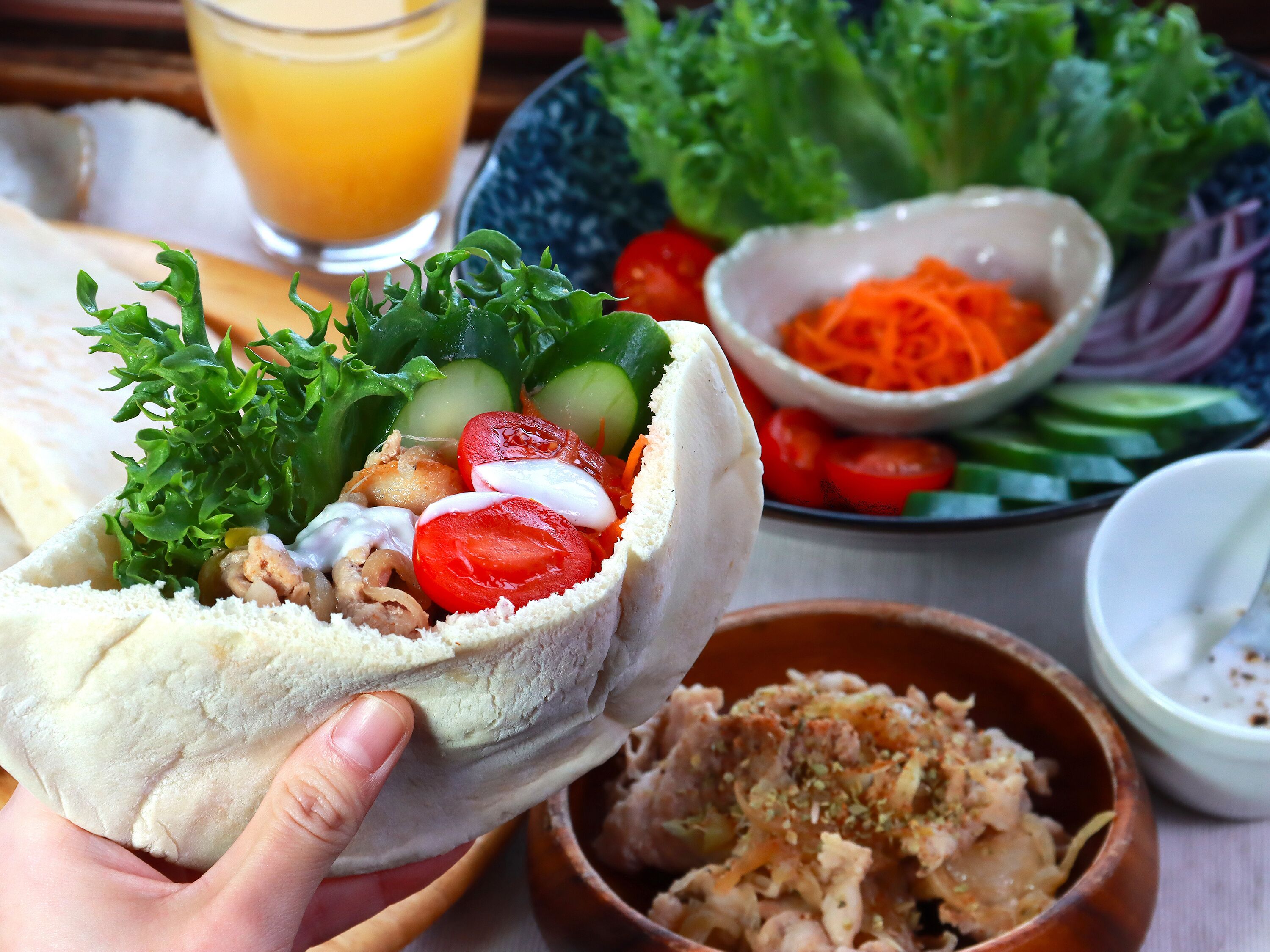A wrap filled with vegetables and a side of salad.