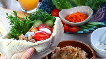 A wrap filled with vegetables and a side of salad.