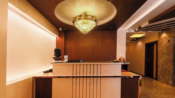 A reception area with a wooden reception desk, a chandelier, and a wooden ceiling. - The Commune KASHI (Varanasi)