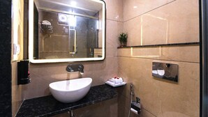 A modern bathroom with a large mirror, a white sink, and a towel rack. - The Commune KASHI (Varanasi)