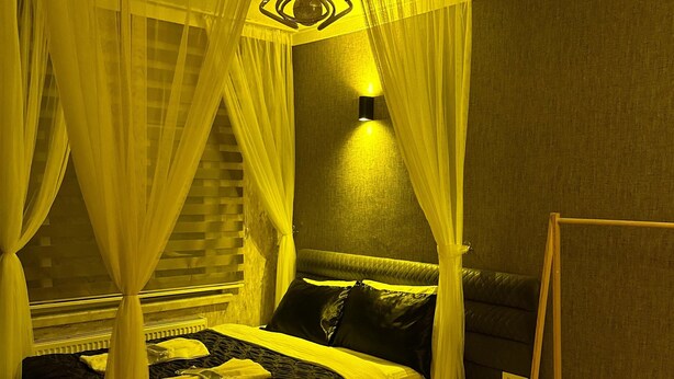A bedroom with a canopy bed, bedside tables, and a nightstand. - ÇANKAYA BOUTİQUE HOTEL (Ankara)