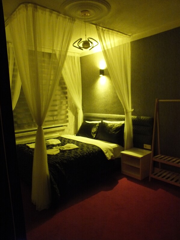 A bedroom with a bed, bedside table, and a nightstand. - ÇANKAYA BOUTİQUE HOTEL (Ankara)