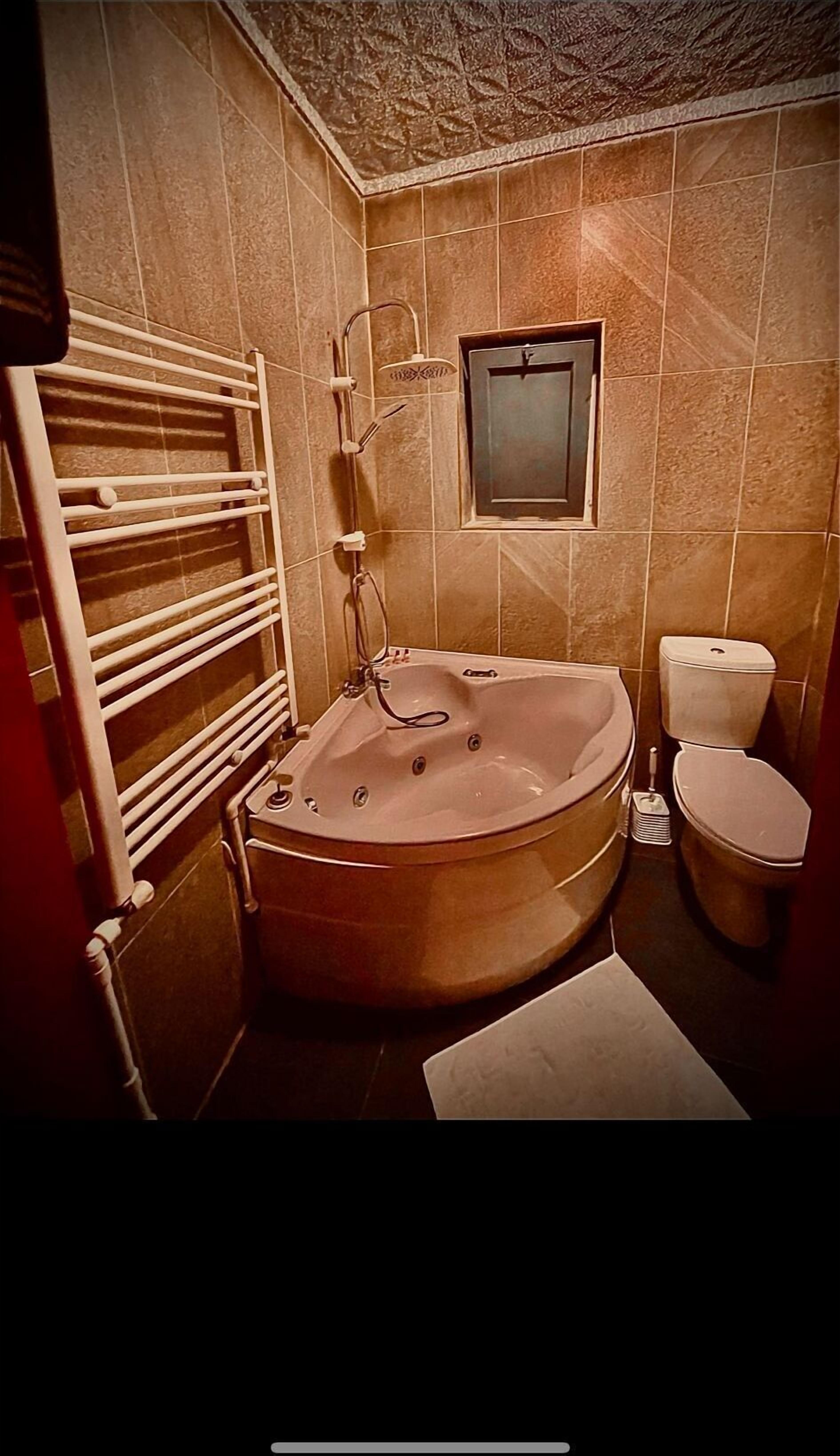 Ein Badezimmer mit einer freistehenden Badewanne, einer Toilette und einem Handtuchhalter.