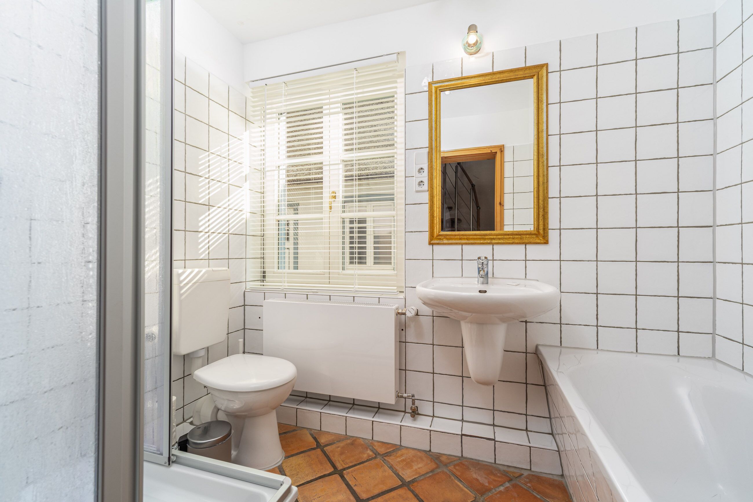 A bathroom with a toilet, sink, and bathtub.